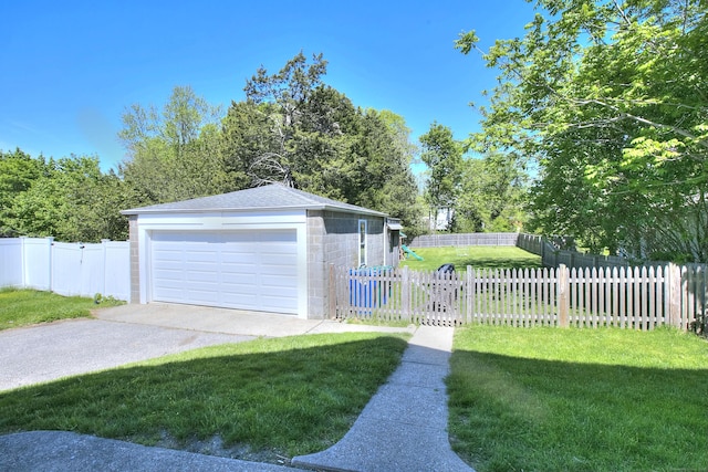 view of front of house with a gate, a garage, an outbuilding, concrete block siding, and roof with shingles