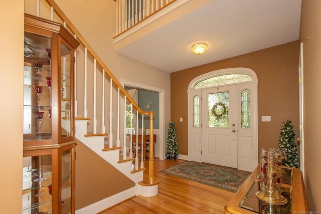 entrance foyer with wood finished floors, stairway, and baseboards