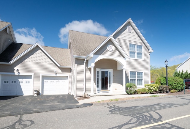 view of front of home featuring a garage, asphalt driveway, and roof with shingles