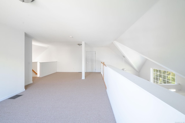 additional living space with light carpet and lofted ceiling