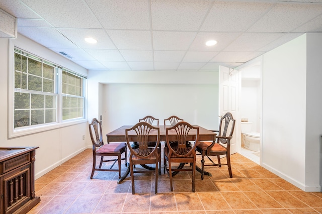 dining room with healthy amount of natural light, a drop ceiling, baseboards, light tile patterned flooring, and recessed lighting