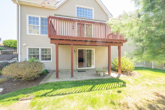 back of property featuring a yard, a wooden deck, and a patio