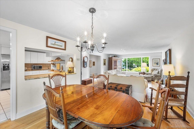 42 N Main St, Essex, CT 06426 - dining room featuring light wood-style flooring, a chandelier, and baseboards