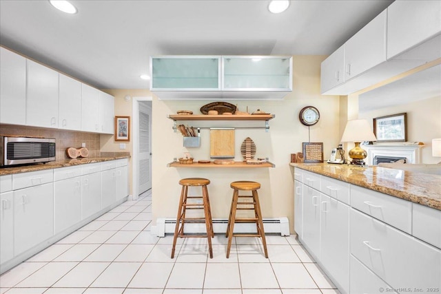 42 N Main St, Essex, CT 06426 - kitchen featuring baseboard heating, recessed lighting, decorative backsplash, white cabinetry, and light stone countertops