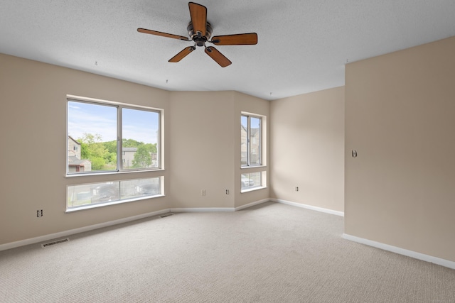 unfurnished room featuring ceiling fan, light colored carpet, and baseboards