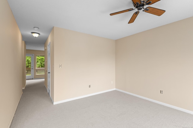 spare room with light carpet, baseboards, and ceiling fan