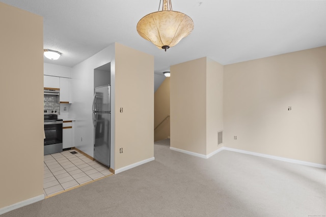 interior space with stainless steel appliances, white cabinets, light carpet, baseboards, and light countertops