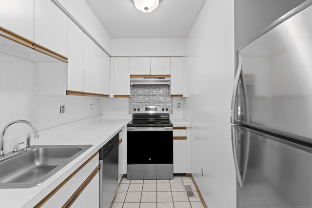 kitchen with appliances with stainless steel finishes, a sink, under cabinet range hood, light tile patterned floors, and white cabinetry