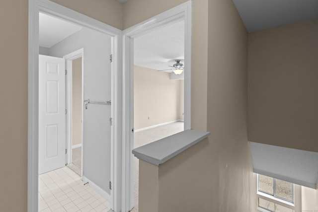 hallway featuring light tile patterned floors and baseboards