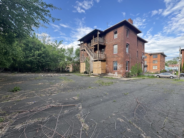149 Wooster St, Hartford, CT 06120 - view of side of home with a balcony, a chimney, and brick siding