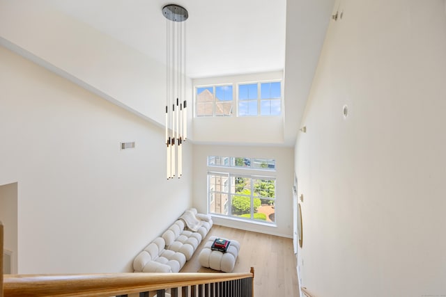 stairway featuring a high ceiling, wood finished floors, and baseboards