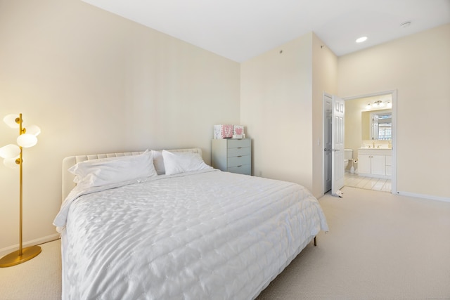 bedroom featuring light colored carpet, baseboards, connected bathroom, a sink, and recessed lighting