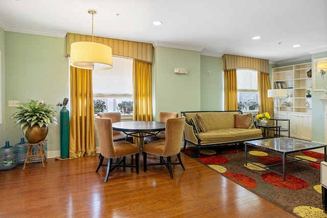 dining area with ornamental molding, wood finished floors, and recessed lighting