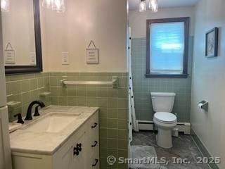 65 Dale Rd, Wethersfield, CT 06109 - bathroom with vanity, a baseboard radiator, wainscoting, and tile walls