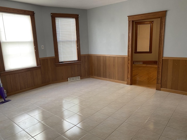 29 Cabot St, New Britain, CT 06053 - spare room with wainscoting, wood walls, and light tile patterned floors