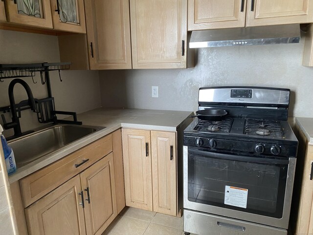 29 Cabot St, New Britain, CT 06053 - kitchen featuring stainless steel range with gas cooktop, under cabinet range hood, light countertops, a sink, and light tile patterned flooring
