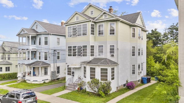 29 Cabot St, New Britain, CT 06053 - view of front facade featuring a front yard, a chimney, a shingled roof, and cooling unit