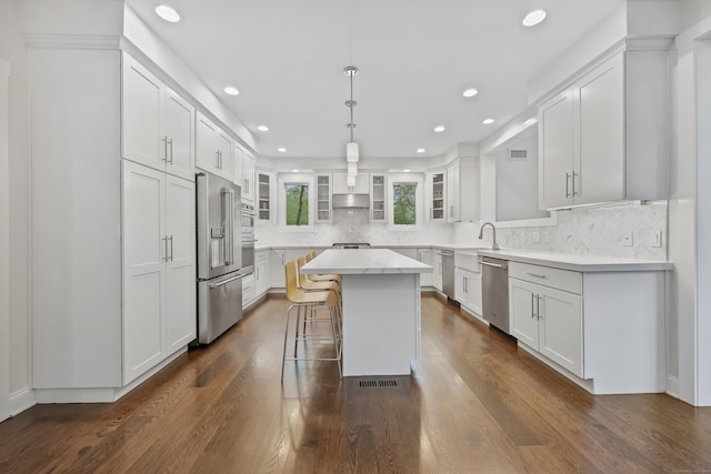 43 Hunting Ridge Rd, Greenwich, CT 06831 - kitchen featuring appliances with stainless steel finishes, a kitchen island, glass insert cabinets, white cabinetry, and dark wood-style flooring