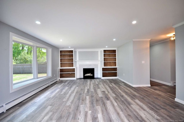 unfurnished living room with baseboard heating, baseboards, recessed lighting, built in features, and wood finished floors