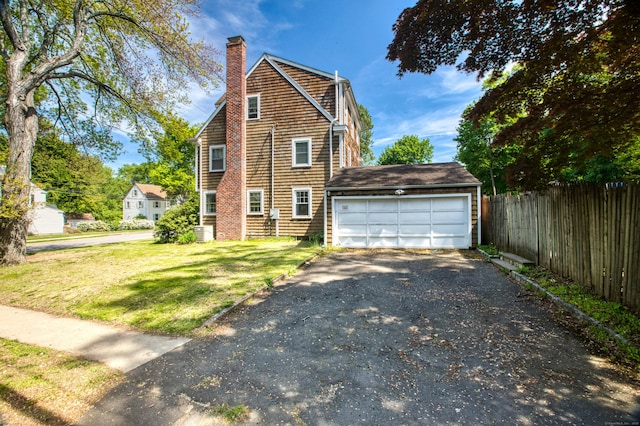 view of front of home featuring a chimney, driveway, and an attached garage