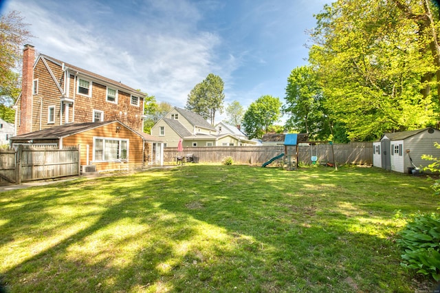 view of yard with a playground, a storage unit, and an outdoor structure