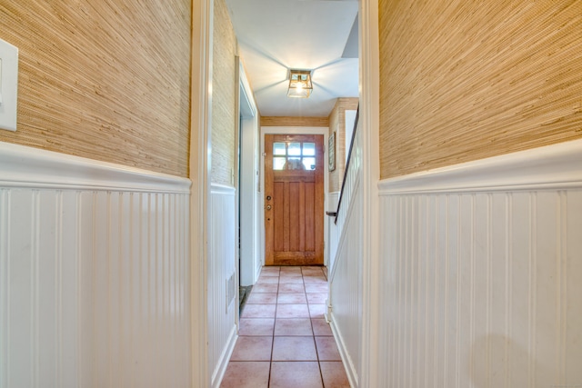doorway featuring tile patterned floors and wainscoting
