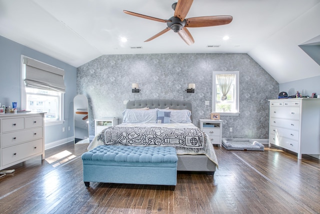 bedroom with lofted ceiling, multiple windows, wood finished floors, and baseboards