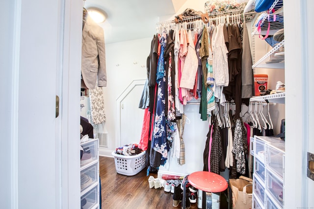 walk in closet with wood finished floors