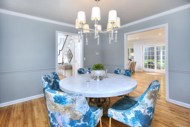 81 Grumman Hill Rd, Wilton, CT 06897 - dining space with a chandelier, light wood finished floors, baseboards, crown molding, and stairs