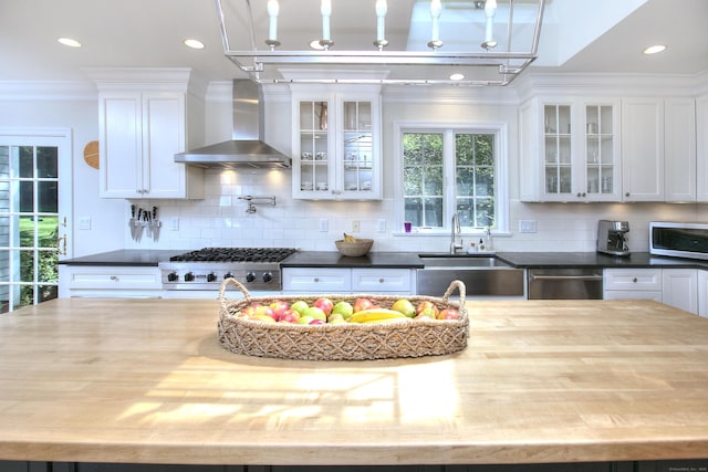 81 Grumman Hill Rd, Wilton, CT 06897 - kitchen with wall chimney range hood, stainless steel appliances, a sink, white cabinetry, and tasteful backsplash