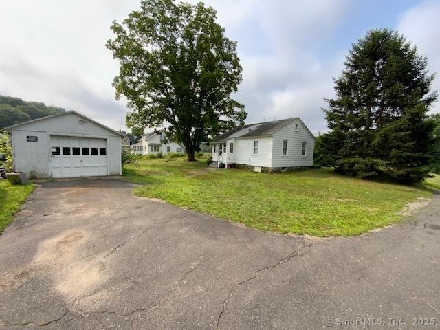 848 New Haven Rd, Naugatuck, CT 06770 - view of front facade with a detached garage, driveway, a front yard, and an outbuilding