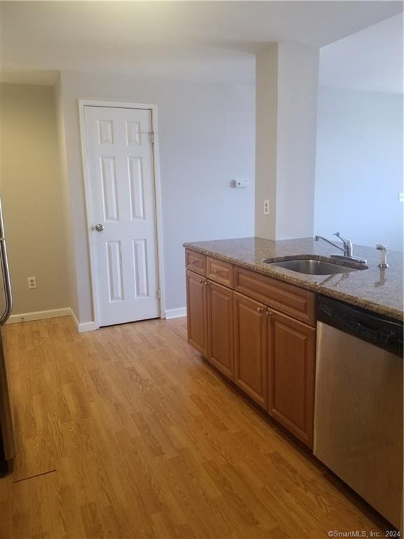 300 Broad St Unit 908, Stamford, CT 06902 - kitchen with stainless steel dishwasher, light stone countertops, light wood-type flooring, a sink, and baseboards