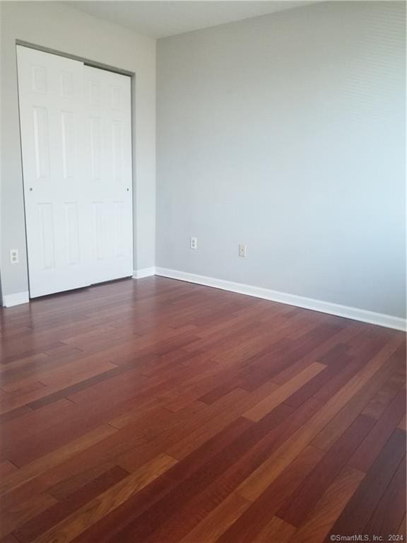 300 Broad St Unit 908, Stamford, CT 06902 - unfurnished bedroom featuring dark wood-style flooring and baseboards