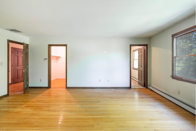 48 Lafayette Dr, Trumbull, CT 06611 - unfurnished bedroom with baseboard heating, light wood finished floors, a spacious closet, and baseboards