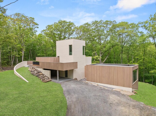 19 Old Paddock Ln, Kent, CT 06785 - contemporary home featuring asphalt driveway, a front yard, a carport, and stucco siding