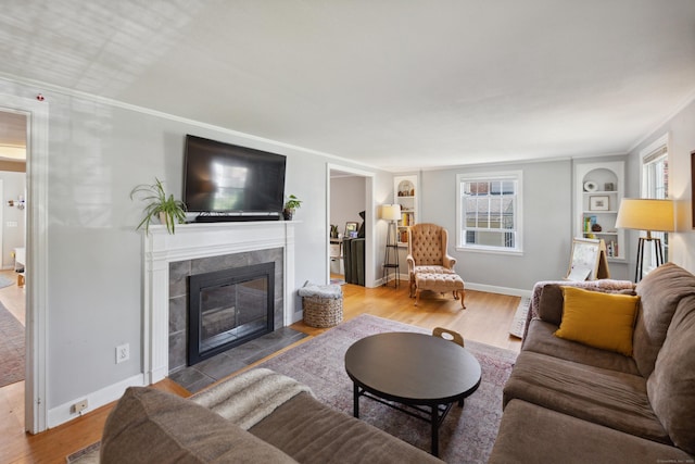 101 White Ave, West Hartford, CT 06119 - living room featuring built in shelves, wood finished floors, a fireplace, and plenty of natural light