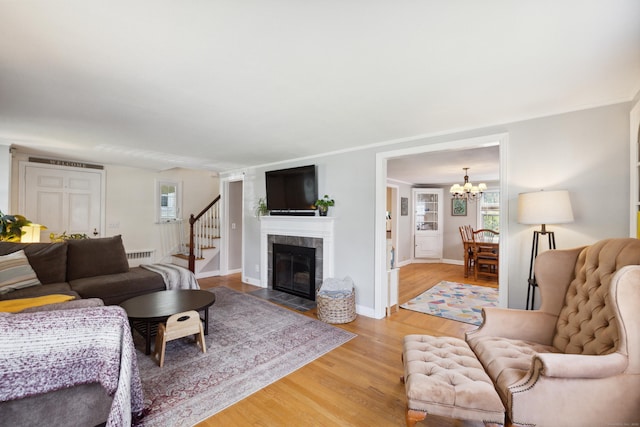 101 White Ave, West Hartford, CT 06119 - living area featuring a chandelier, light wood finished floors, a baseboard heating unit, baseboards, and a tiled fireplace