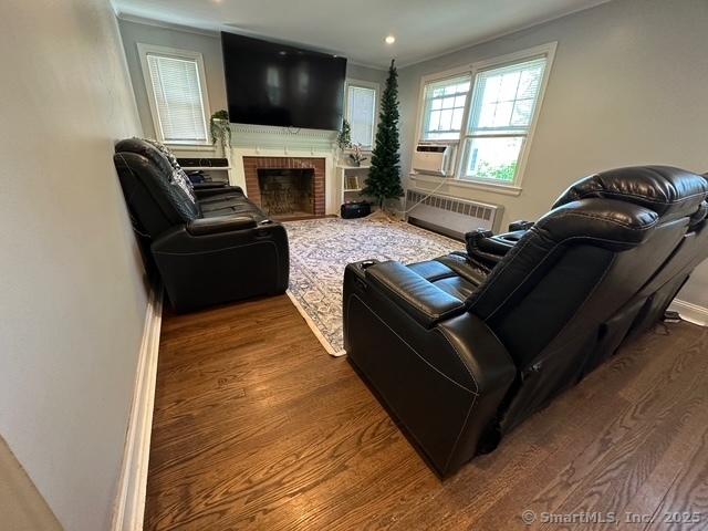 794 Center St, Manchester, CT 06040 - living room with radiator, wood finished floors, crown molding, a brick fireplace, and cooling unit