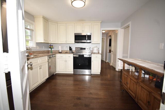 794 Center St, Manchester, CT 06040 - kitchen featuring stainless steel appliances, dark wood-style floors, light stone counters, and cream cabinetry