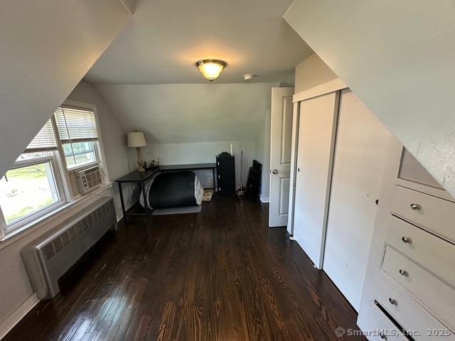 794 Center St, Manchester, CT 06040 - unfurnished bedroom featuring radiator heating unit, dark wood finished floors, lofted ceiling, a closet, and cooling unit