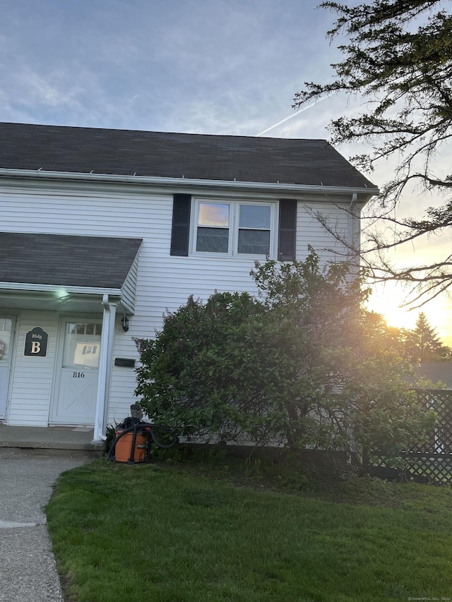 view of home's exterior featuring a yard and a shingled roof