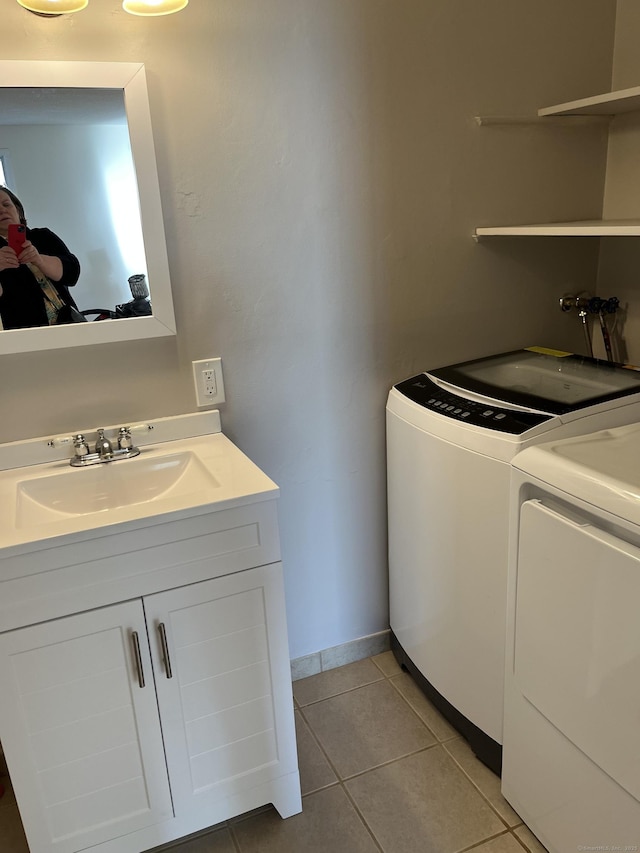 clothes washing area featuring washer and dryer and light tile patterned floors
