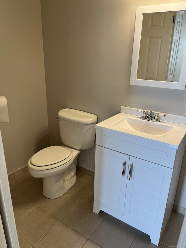 bathroom featuring baseboards, toilet, tile patterned floors, and vanity
