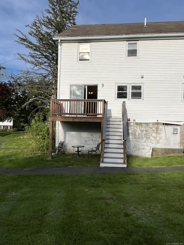 back of property with a lawn, stairs, and a deck