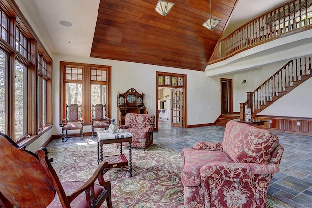 living room with baseboards, wooden ceiling, high vaulted ceiling, and stairs