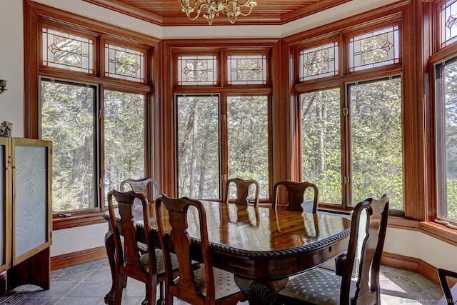 sunroom / solarium with baseboards, crown molding, and a chandelier