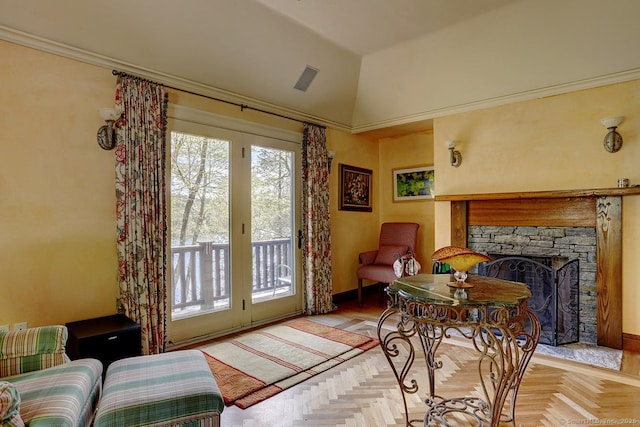 living area with a stone fireplace, baseboards, lofted ceiling, and crown molding