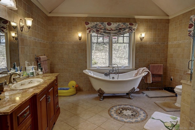 bathroom featuring vaulted ceiling, tile walls, tile patterned floors, vanity, and ornamental molding