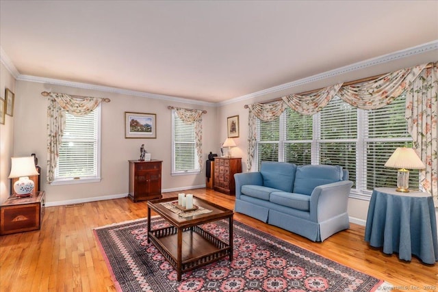 living room featuring crown molding, light wood-style flooring, and baseboards
