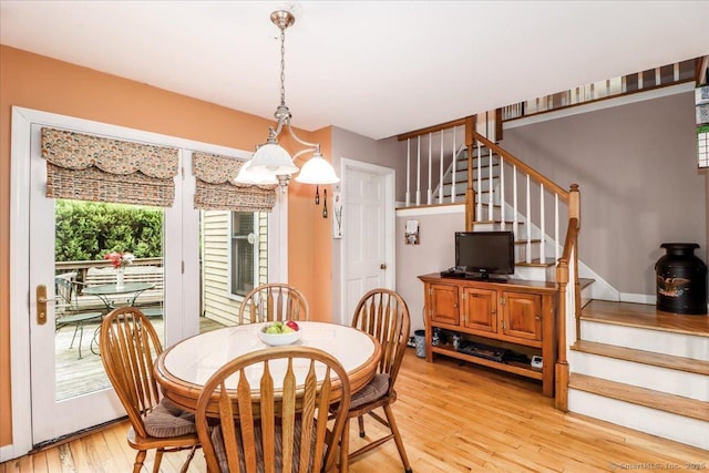 dining room featuring stairs and light wood-type flooring